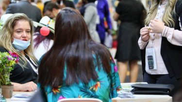 A woman presenting with a laptop to the man beside her