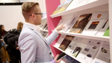 A man looking on the WTM London brochures