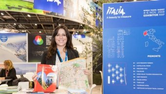 a lady receptionist giving map and guide to wtm london event